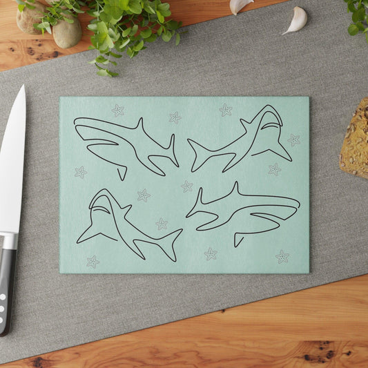 Shark and Starfish Line Art Glass Cutting Board on table